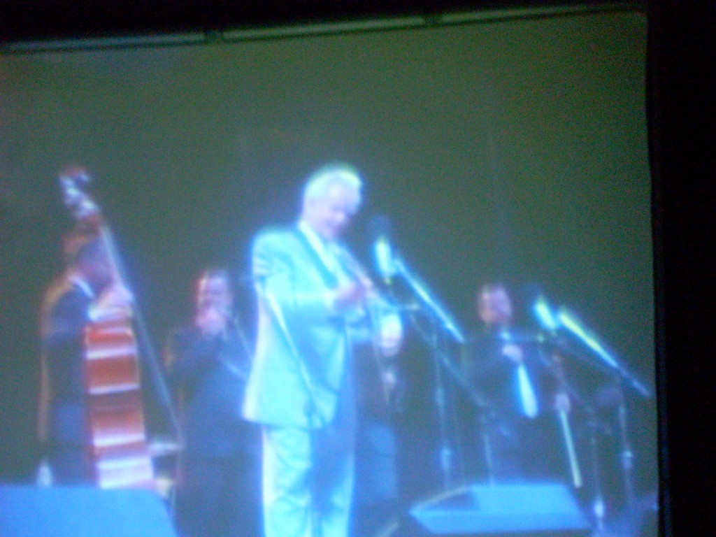 Greetings from the Grey Fox Bluegrass Festival in Oak Hill, NY... just south of Albany, in the foothills of the Catskill mountains.   This is Del McCoury (on the JumboTron).  Yes, the photo is 'backwards'.  I was standing backstage behind the JumboTron, so all images were reversed.  Del turns 75 this year, and the Grey Fox crowd LOVED celebrating his milestone!