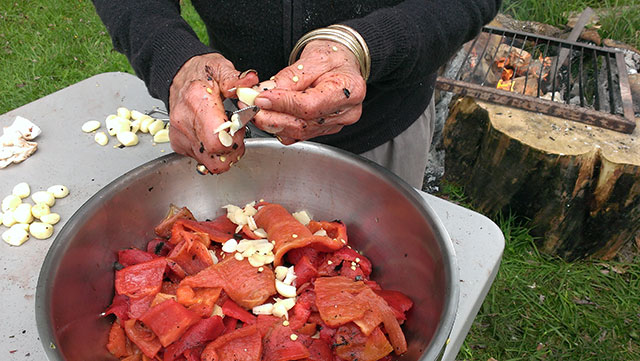 Adding the garlic to the peeled, cut up roasted peppers. Add olive oil, put in bags and freeze. Photo: Mary McCallion