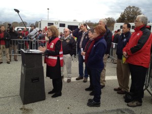 Red Cross CEO Gail McGovern speaks at a post-Sandy press conference on Staten Island with emergency response vehicles as backdrops. Relief workers were angered that the vehicles were diverted for public relations purposes. (Via ProPublica: Catherine Barde/American Red Cross via Flickr)