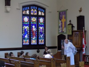 Rev. Dr. Bryan King, Pastor of St. Luke Lutheran Church, preaching the Children's sermon on Doors Open Sunday.  The stained glass Good Shepherd Window honors Rev. Alfred Dashner, one of the church's longest serving pastors.  Photo by James Morgan