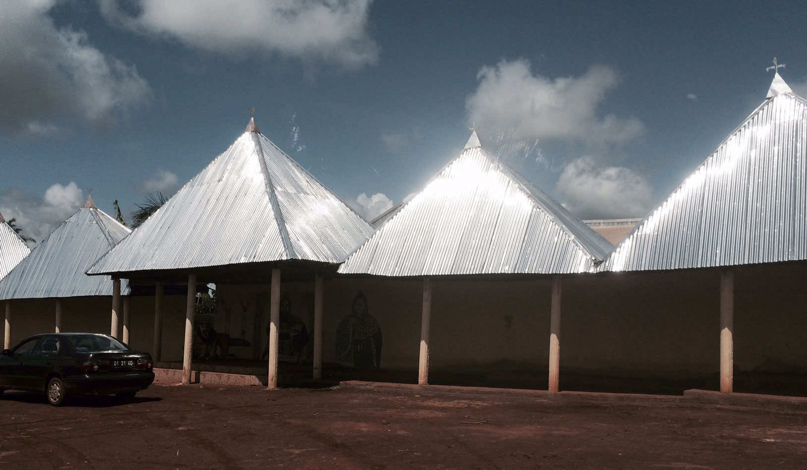 The exterior of the village palace, the Chief's residence. In this area of Cameroon, the pointed metal roof indicates a high position in the community. Photo: Ellen Rocco