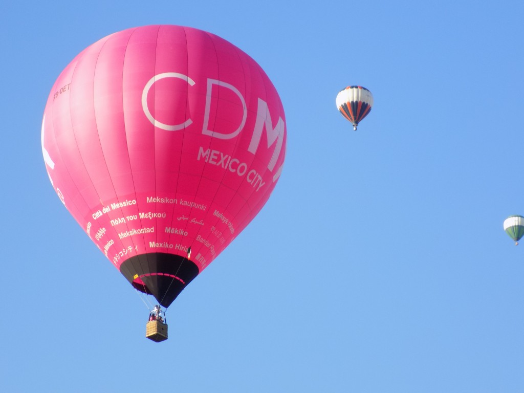 The pink balloon on the left is from Mexico City and was at the festival to promote tourism.  The balloon further away at the right is from Quebec.  Photo by James Morgan