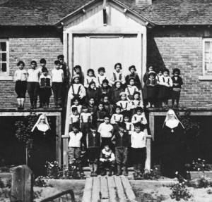 Children and nuns in front of the Indian Residential School, Maliotenam, Quebec, circa 1950. Photo: Library and Archives Canada