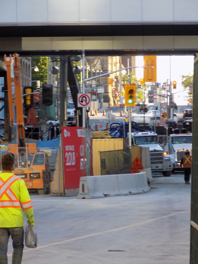 Crews spending a Friday evening at the site of the Rideau Street sinkhole.  The Rideau Centre mall is at the left.  Photo by James Morgan