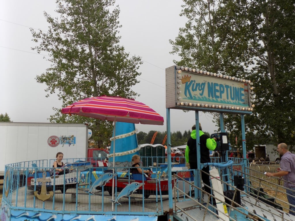 Even the smallest fairs manage to have a few midway rides and carnival games.  Merrickville is in Canada and  400 miles/640 km by car from the Atlantic Ocean and New York City, but there was a ride called "King Neptune" featuring boats with NYPD and US Coast Guard lettering on them.  Photo by James Morgan 