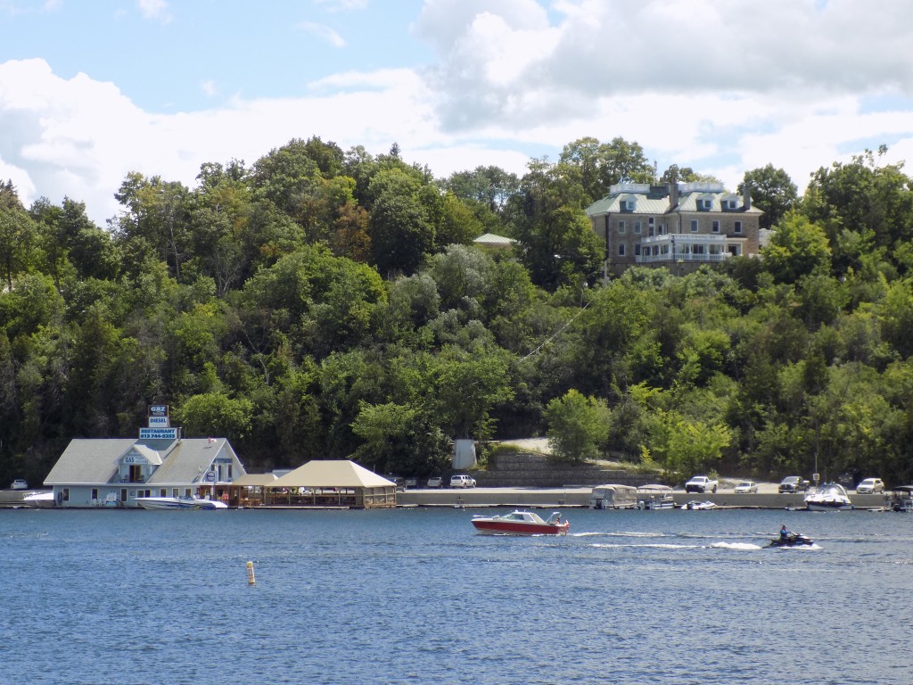 The Ottawa River is busy on a summer Saturday with lots of boat traffic and business at marinas below Ottawa's posh Rockcliffe Park neighborhood.  The mansion shown is Lornado, residence of the US Ambassador to Canada.  Photo by James Morgan