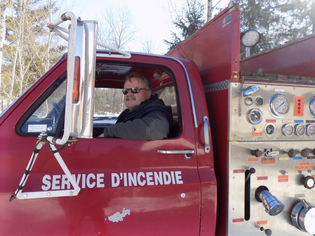 Dave Mayer behind the wheel of the former fire truck he uses to flood the skating path on his property.  Photo: James Morgan