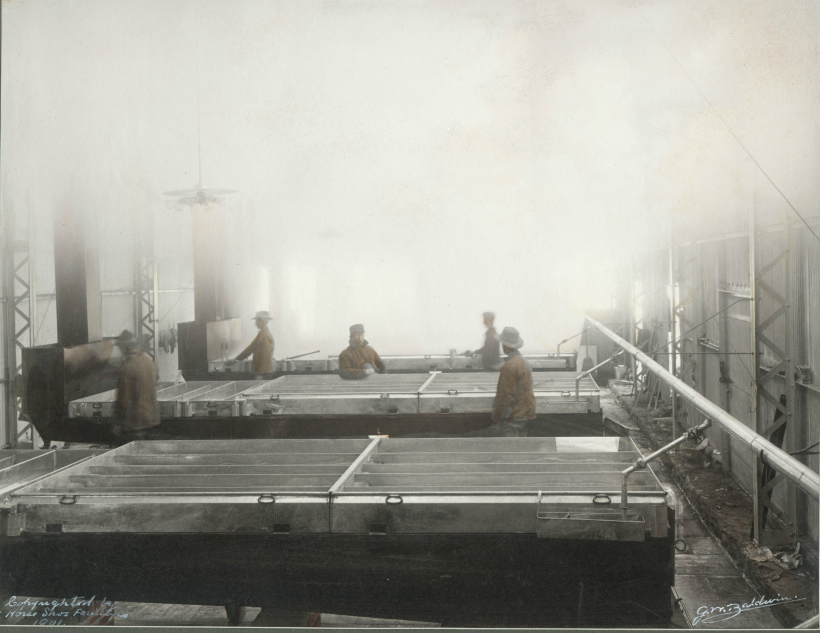 203.View of the interior of one of the Horse Shoe Forestry Company's 4 sugarhouses.  Shows five men tending the patent evaporator pans developed by John Rivet and James Hill and patented for them by Low.  Horse Shoe Forestry Co. in Tupper Lake, 1901."  Photo: G.W. Baldwin