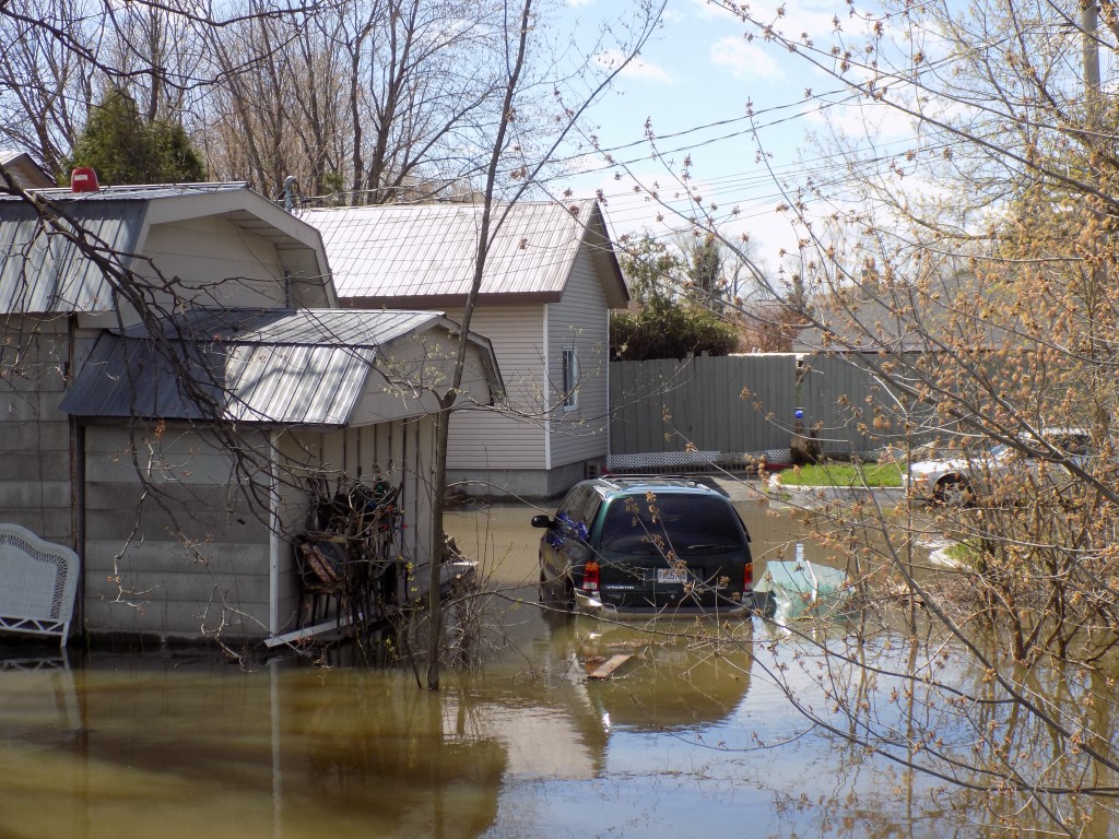 A flooded home on Jacques Cartier Street.  Ironically, the rowboat to the right of the minivan has been left upside down to keep rainwater out!  Photo: James Morgan