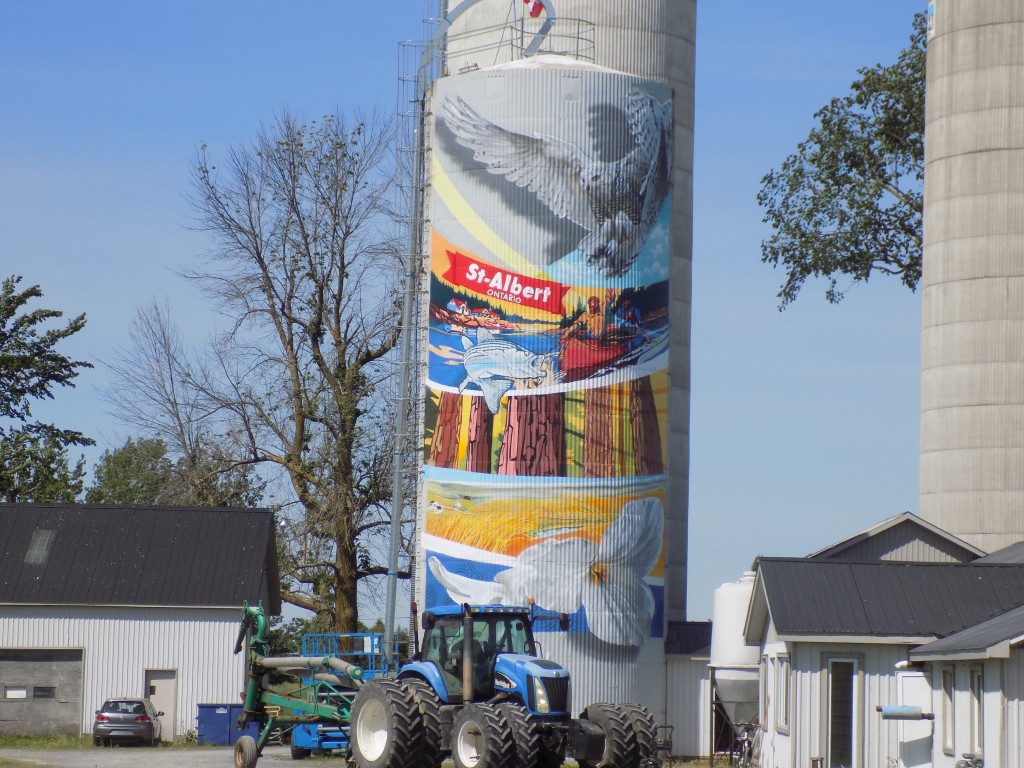 This mural by Montreal artists Benny Wilding and Carlos Oliva is on the silo at Ben-Rey-Mo Ltd. Farm.  It's located at 127 Principale Street at the edge of the village of St. Albert.  Dairy farms are a big part of the local economy.  The farm is just around the corner from the St. Albert Cheese Co-operative's factory, store, and restaurant, which is a popular tourist destination.  Photo: James Morgan