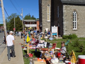 Trash and Treasure on the lawn of St. Gregoire parish.  A young popcorn vendor is at the right.  Photo: James Morgan