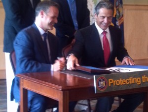 Governor Cuomo (R) and Bill Ulfelder, executive director of New York's Nature Conservancy signing the Finch Pruyn deal in August 2012  (Photo:  Brian Mann)