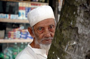 Are you afraid of a hat? Should you be? Image by Nafis Kamal of old Bangladeshi man with a grey beard, wearing a white Muslim cap. Creative Commons